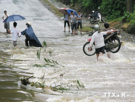 Người dân khênh xe máy qua đập tràn suối Trát, huyện Bảo Thắng (Lào Cai).